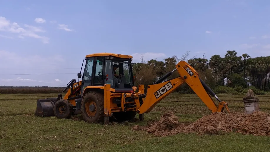 Excavator lifting a tree stump